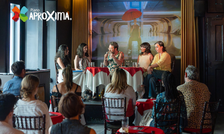 Mesa-redonda Invisíveis na Pensão Amor com cinco pessoas no palco e uma plateia de participantes.