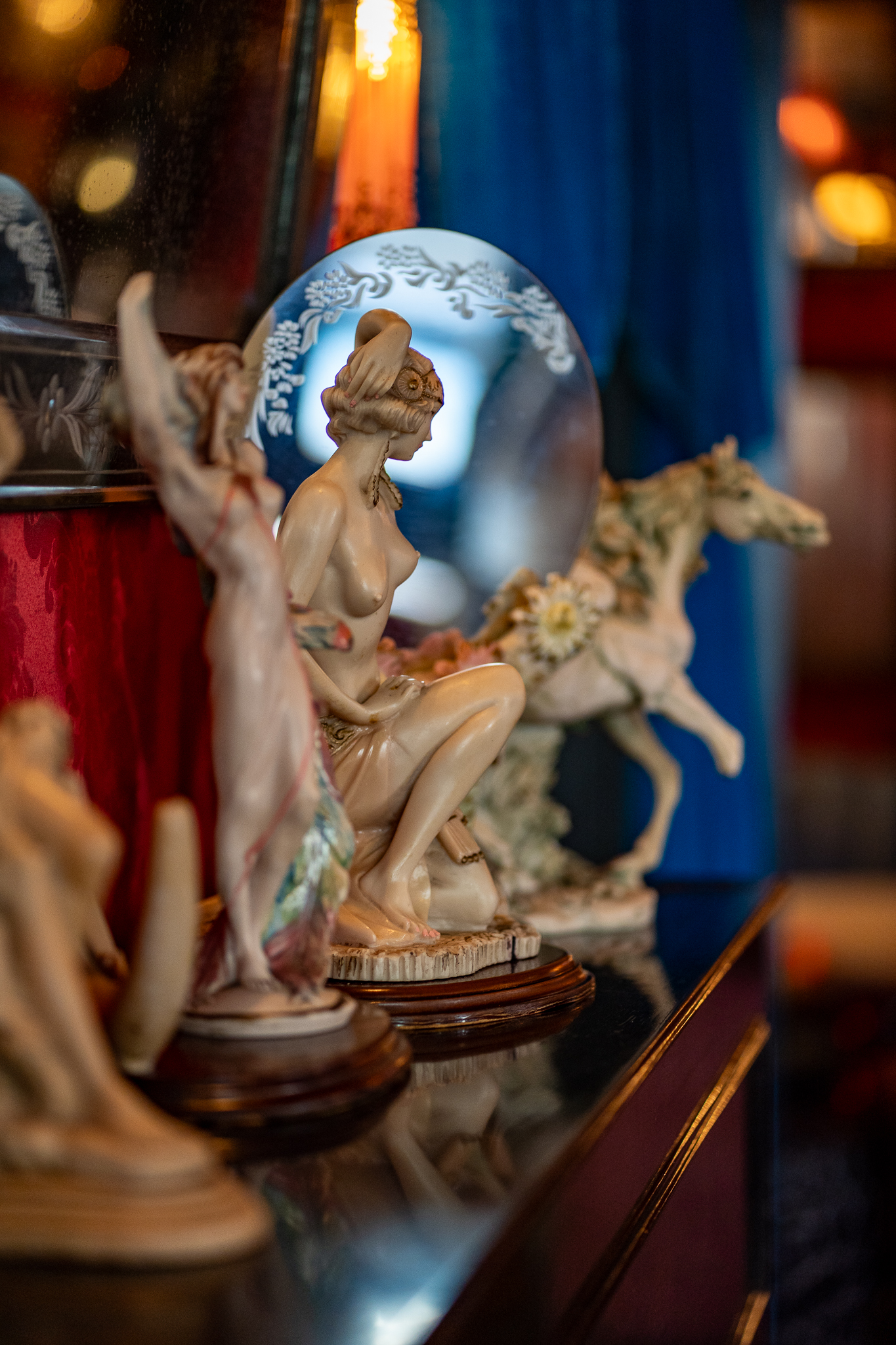 Estatuetas decorativas em estilo vintage sobre uma consola.