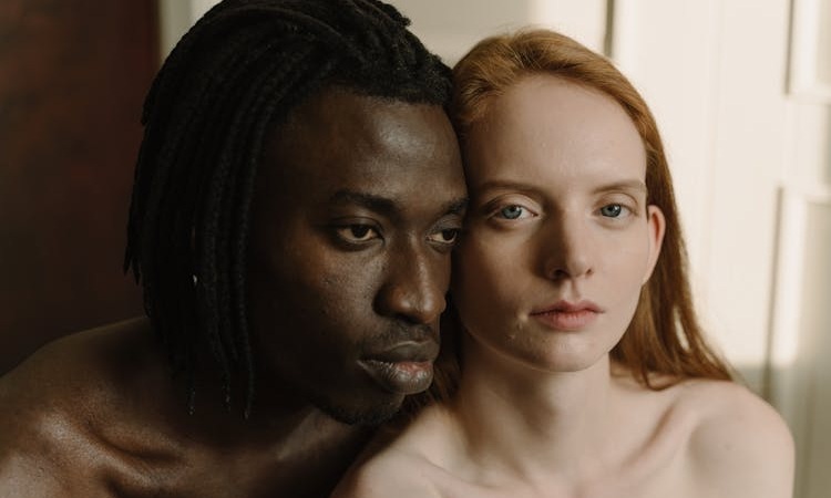 casal com os rostos colados um no outro, com semblante introspetivo