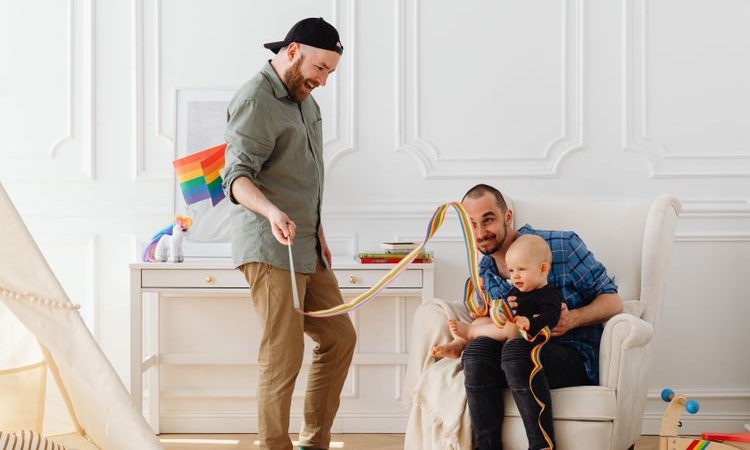 casal homossexual brinca com filhx na sala