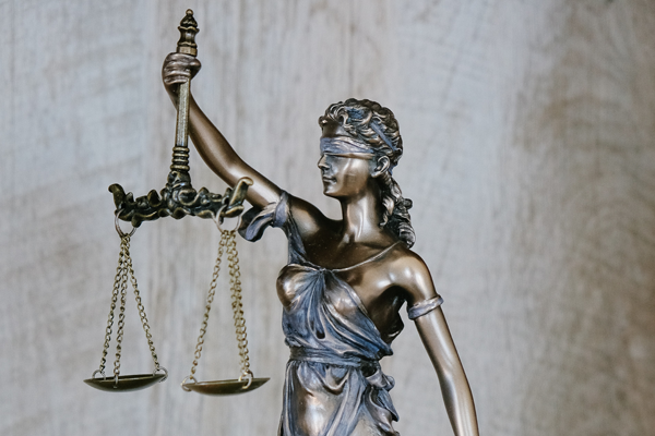 Estatua de uma mulher com uma fita a tapar os olhos e a mesma está a segurar uma balança