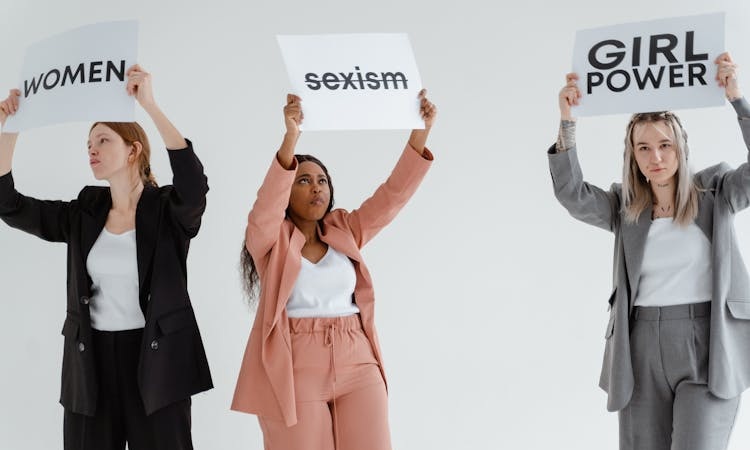 mulheres seguram papéis contra o sexismo