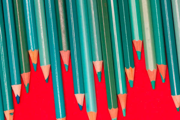 v&aacute;rios lapis de cor verde num fundo vermelho