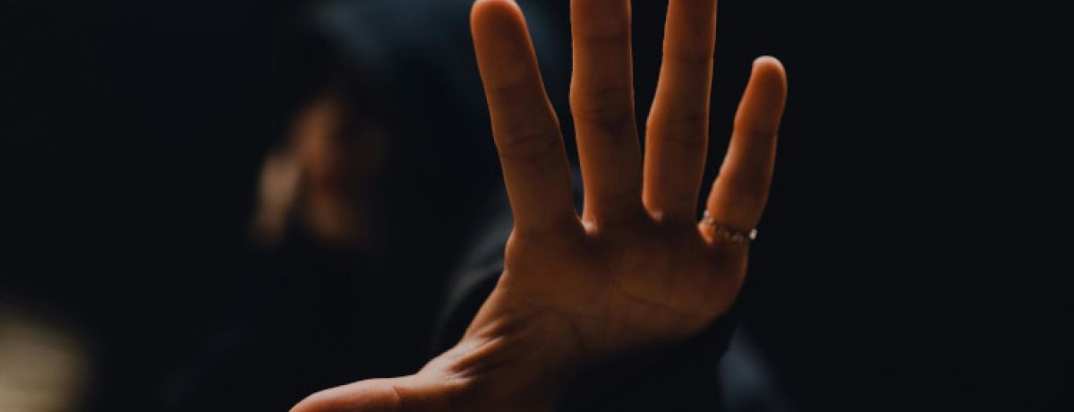 Imagem de uma mão com um fundo escuro de alguém a tentar saber como estabelecer limites no Trabalho Sexual.