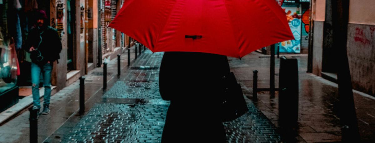 Mulher de costas com chapéu vermelho na rua, no Dia Contra a Violência sobre Trabalhadorxs do Sexo