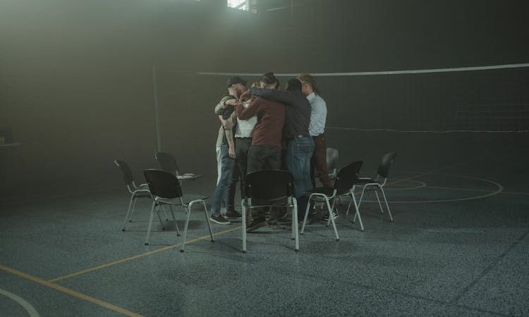 grupo de amigos abraçado em campo de voleibol
