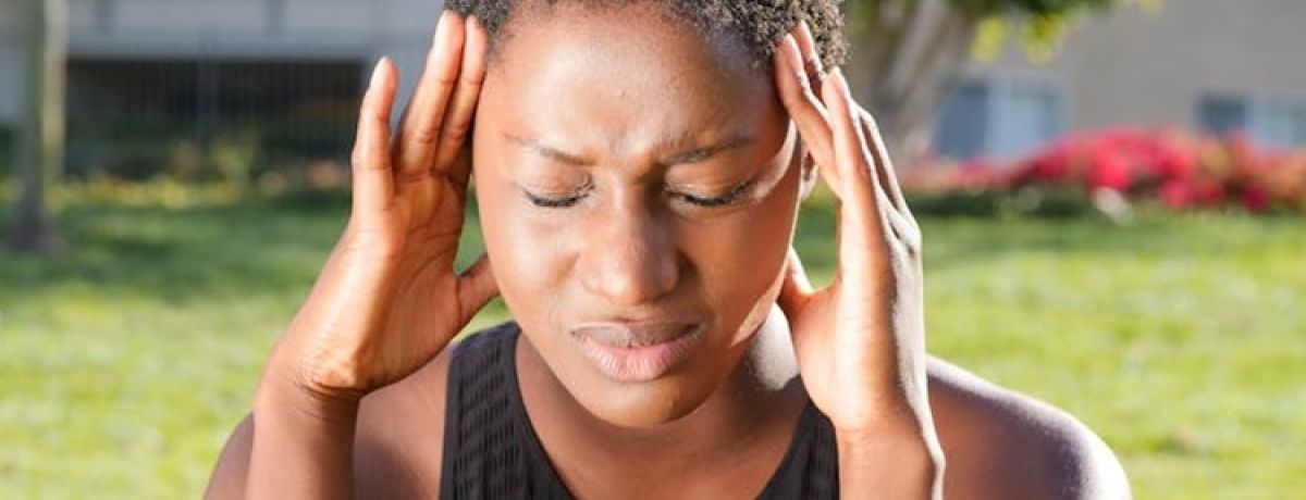 mulher com stress pressiona as laterais da cabeça com os dedos
