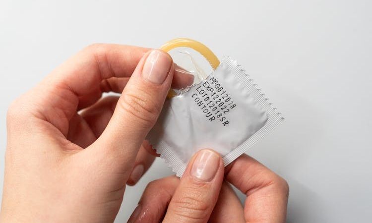 pessoa abre embalagem de preservativo