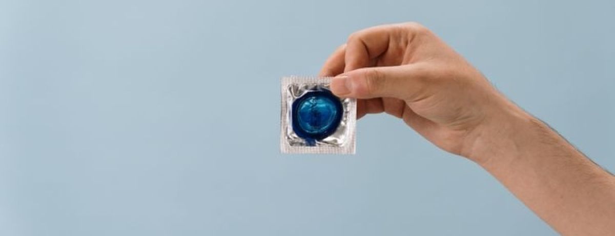 pessoa segura embalagem de preservativo azul com a mão
