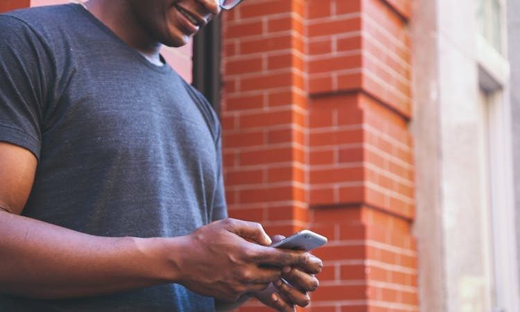 pessoa com telemóvel na mão a marcar consulta no SNS