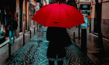 Mulher de costas com chapéu vermelho na rua, no Dia Contra a Violência sobre Trabalhadorxs do Sexo