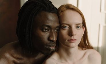 casal com os rostos colados um no outro, com semblante introspetivo