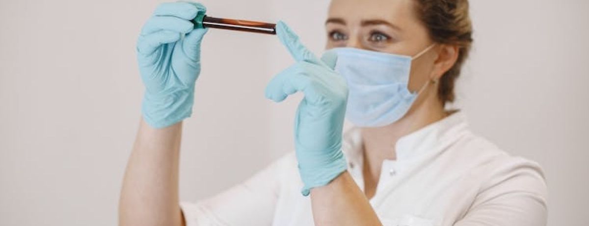 profissional de enfermagem usando EPI segura tubo de sangue para análise nas mãos