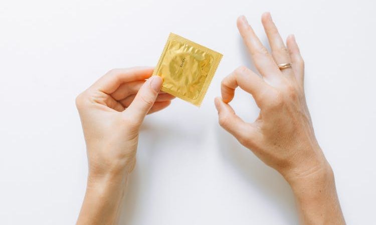 pessoa pega em preservativo fechado