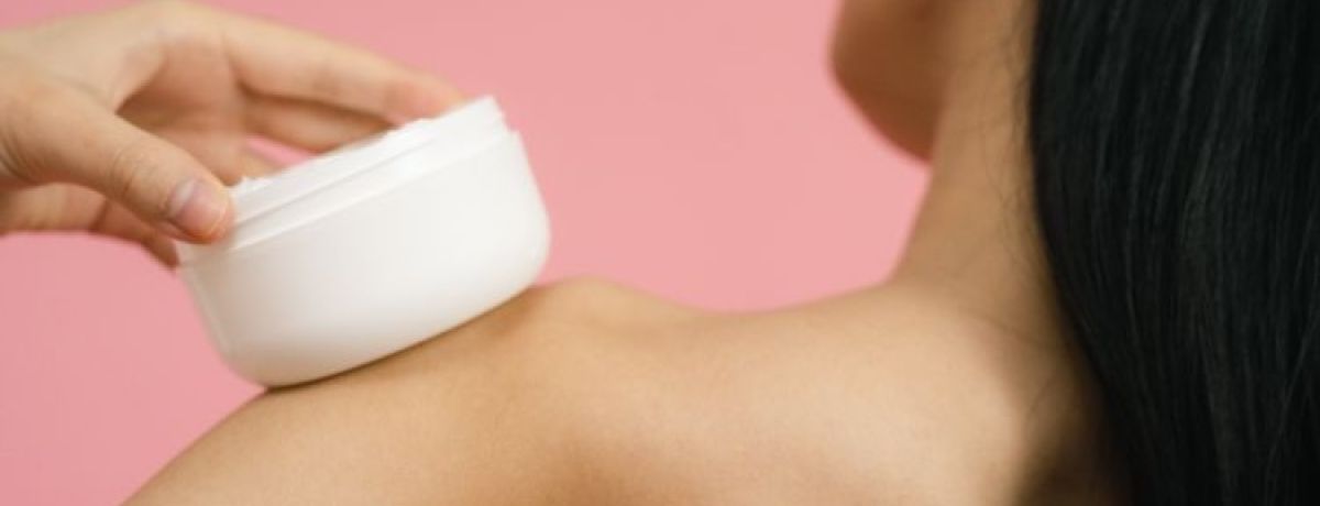 mulher segura sobre o ombro creme hidratante para cuidar da barreira cutânea danificada
