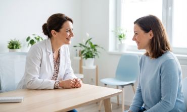 mulher em consultório com uma ginecologista