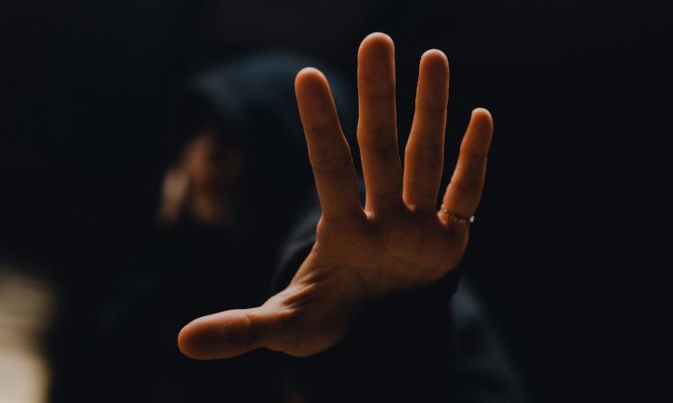 Imagem de uma mão com um fundo escuro de alguém a tentar saber como estabelecer limites no Trabalho Sexual.