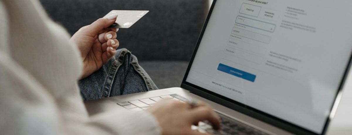 mulher vê código de cartão bancário para inserir no computador