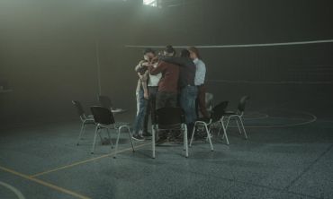 grupo de amigos abraçado em campo de voleibol