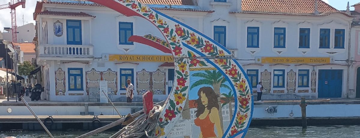 Parte de trás de barco colorido com flores e desenho de mulher na ria de Aveiro.
