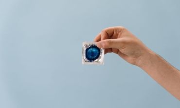 pessoa segura embalagem de preservativo azul com a mão