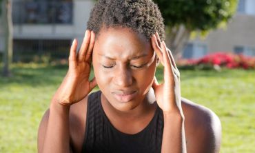 mulher com stress pressiona as laterais da cabeça com os dedos