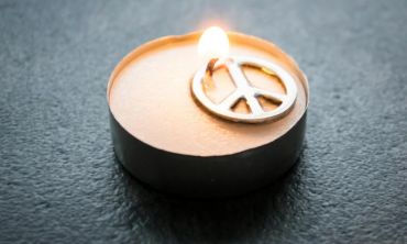 vela acesa com o símbolo da paz