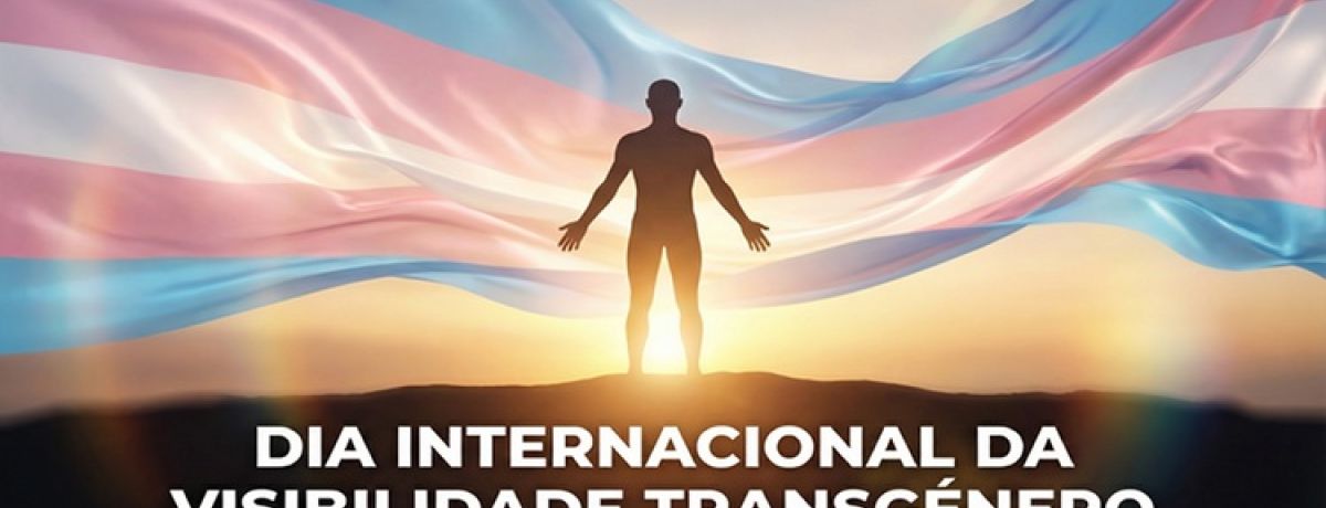 pessoa trans de braços abertos, com bandeira trans por trás, celebrando o dia internacional da visibilidade transgénero