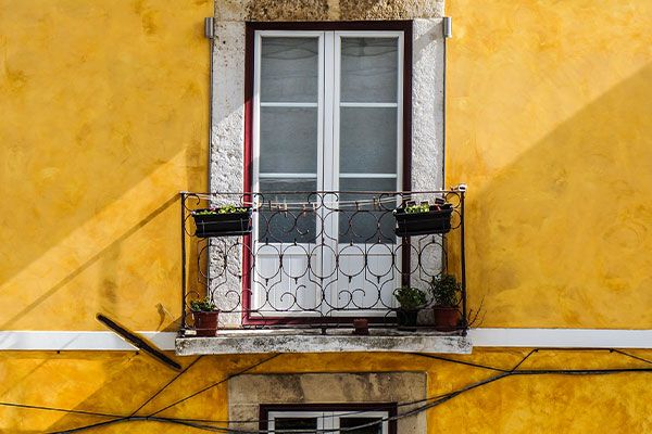 Varanda de uma casa portuguesa com pintura amarela á volta